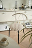 Comfy chair with patterned cushion in a room with a desk and decor items.