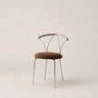 Modern chair with metal frame and brown cushion on a beige background