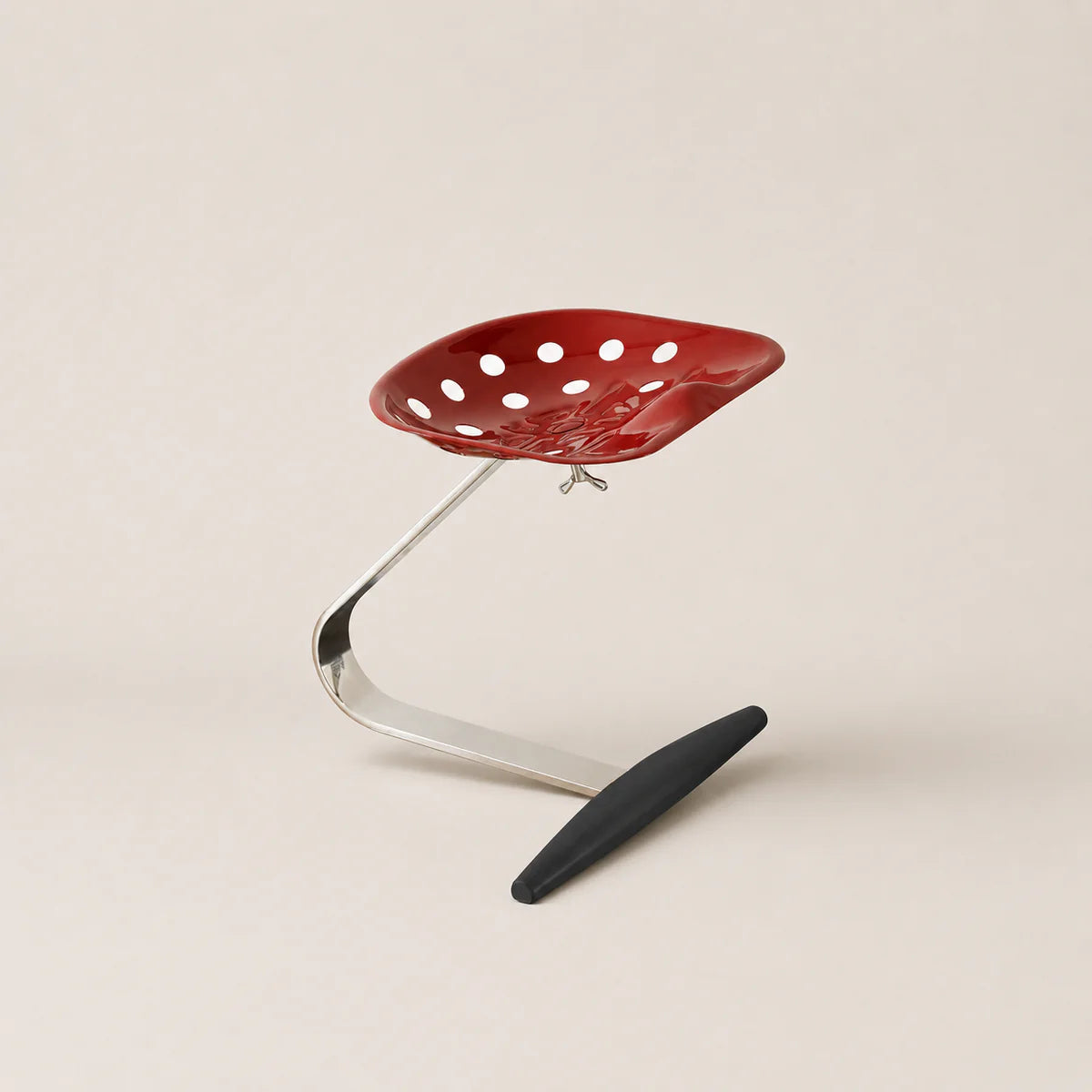 Red chair with a black footrest on a beige background
