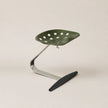 Green chair with perforated design on a beige background