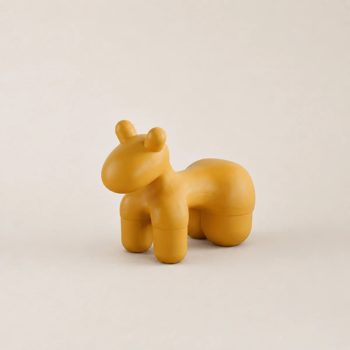 Yellow hippo-shaped container on a beige background