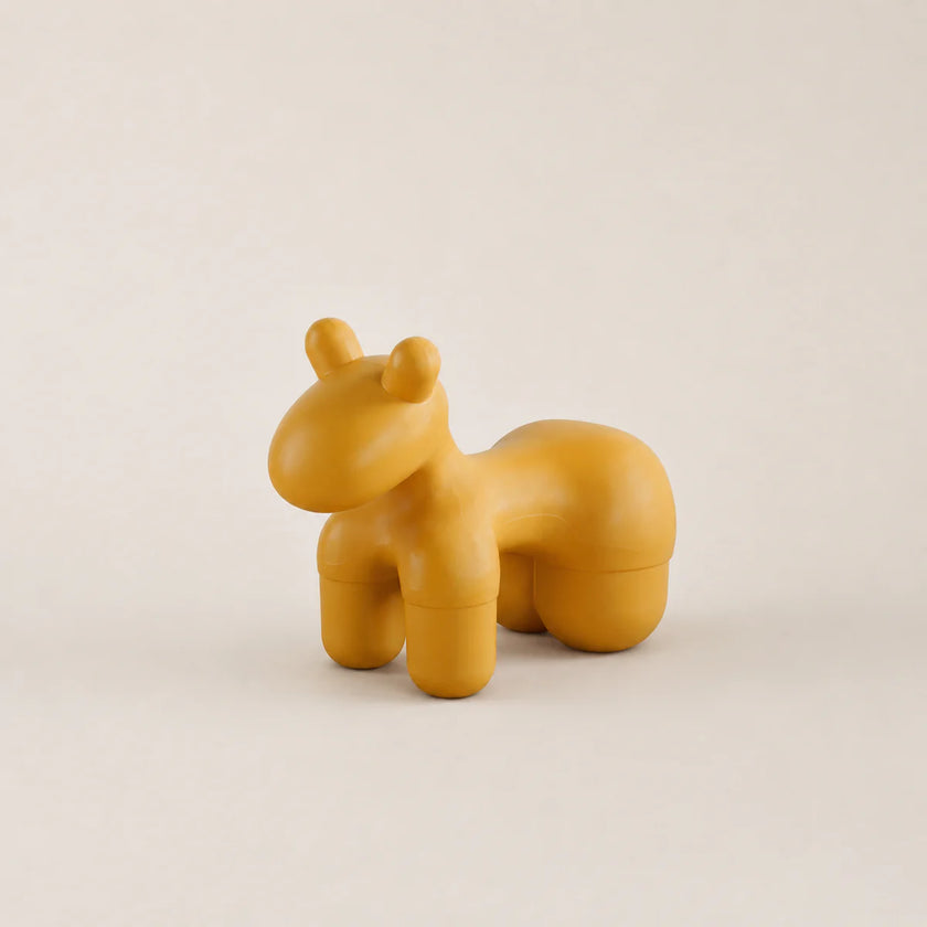 Yellow hippo-shaped container on a beige background