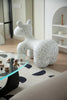 Speckled gray animal sculpture living room chair in a modern room with a glass table and abstract rug.
