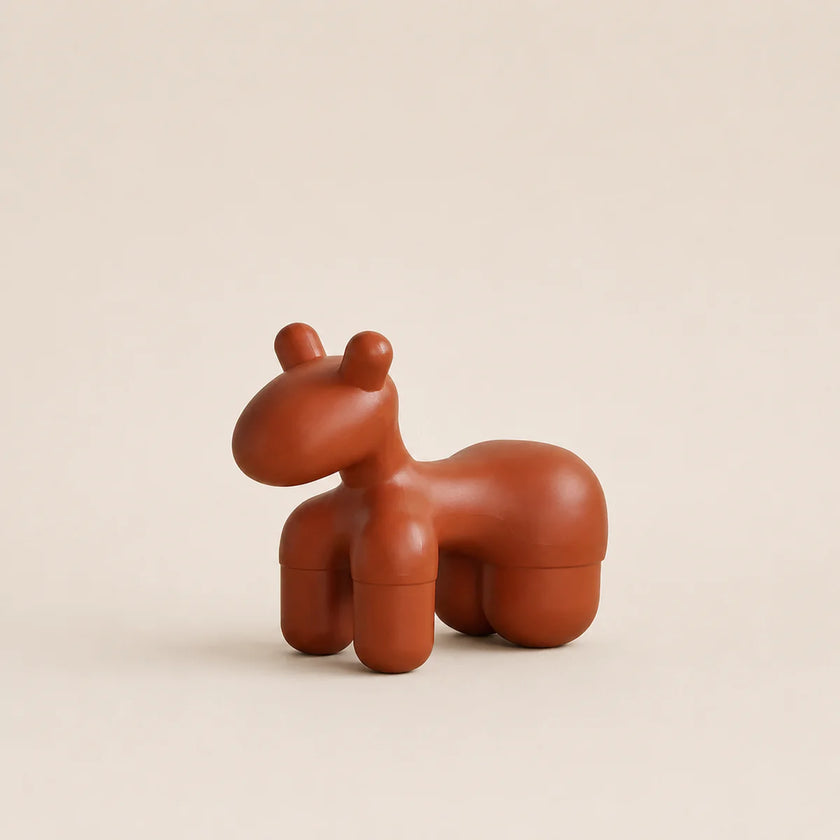 Brown ceramic horse-shaped object on a beige background