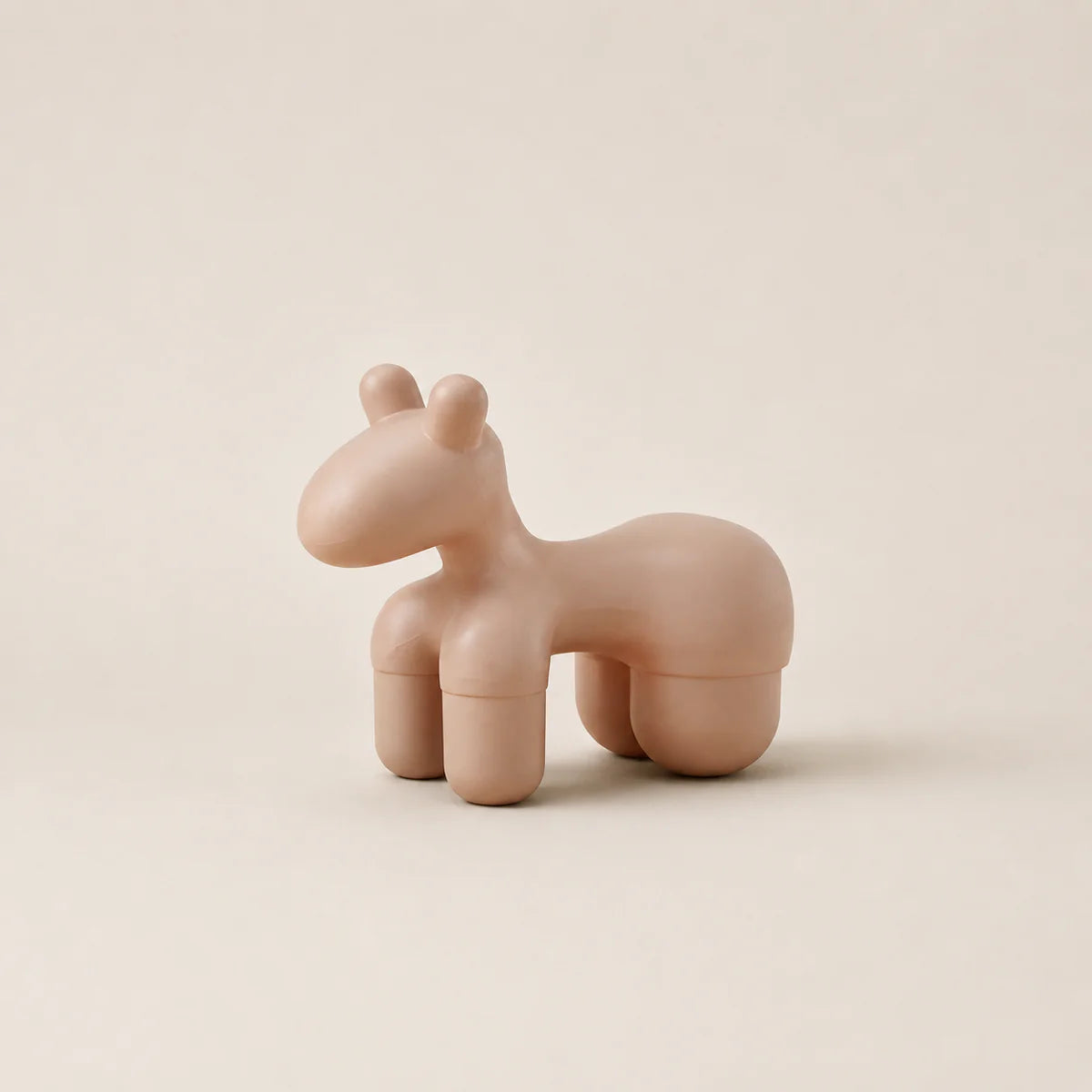 Pink horse-shaped container on a beige background