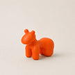 Orange horse-shaped object on a beige background