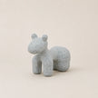Speckled gray ceramic horse figurine on a beige background