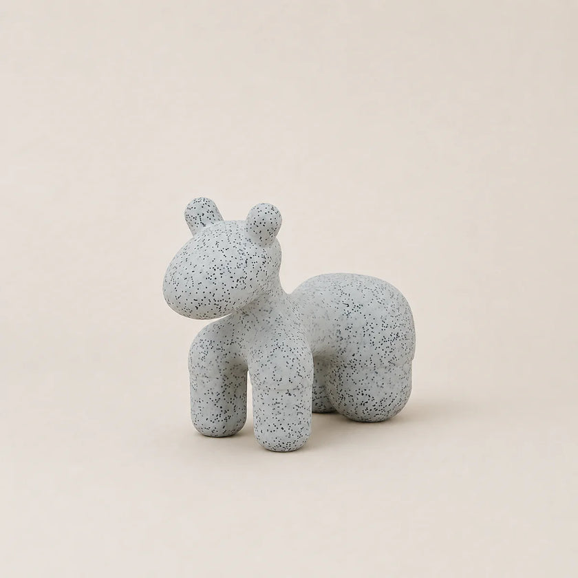 Speckled gray ceramic horse figurine on a beige background