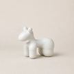 White ceramic horse sculpture on a beige background