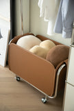 Modern brown rolling storage coat rack with wheels in a room setting