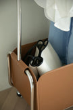 Close-up of a brown storage coat rack with a white bag inside, against a neutral background.
