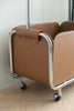 Brown  storage cube rolling cart with wheels on a light wooden floor.