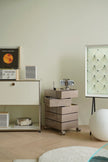 Modern room interior with a storage containers dresser, drawers, and a screen displaying a pattern.