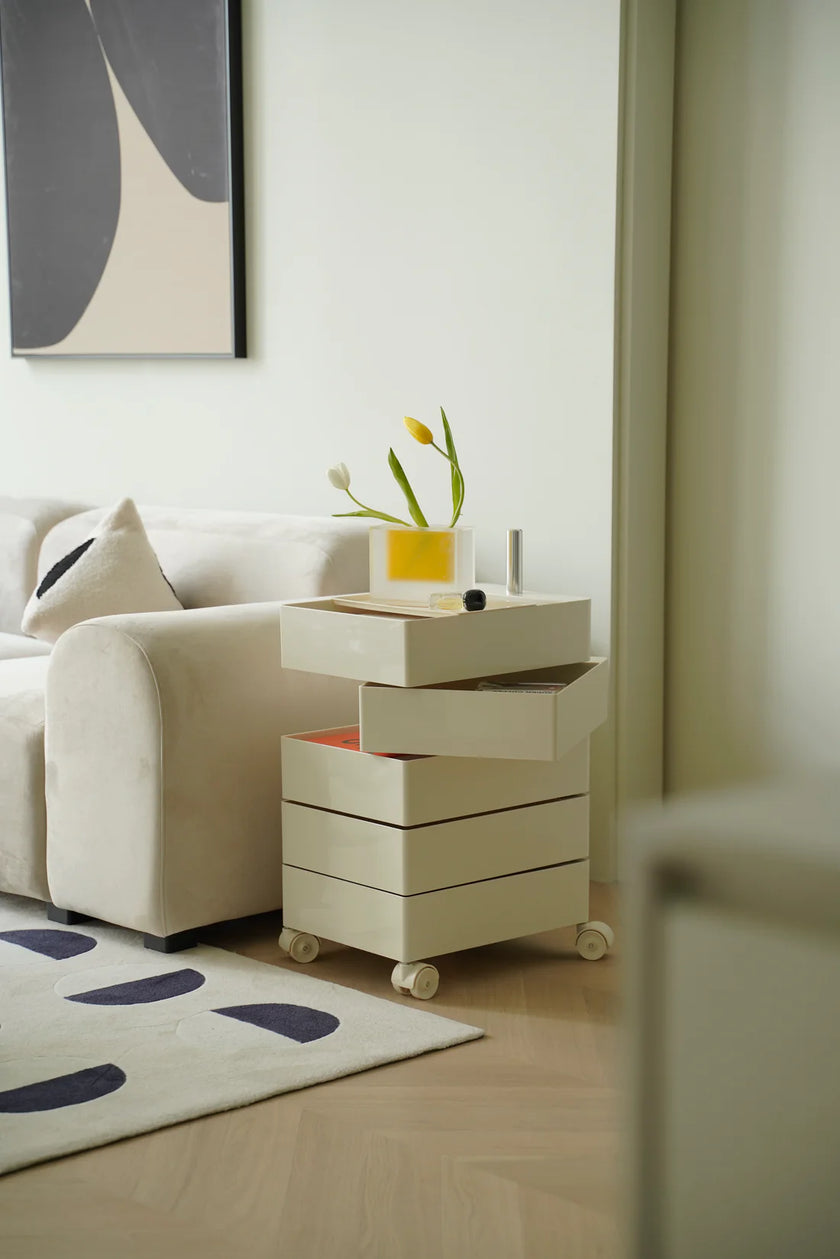 Modern living room with a beige sofa, storage cube rolling cart with drawers, and abstract art on the wall.
