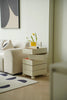 Modern living room with a beige sofa, storage cube rolling cart with drawers, and abstract art on the wall.