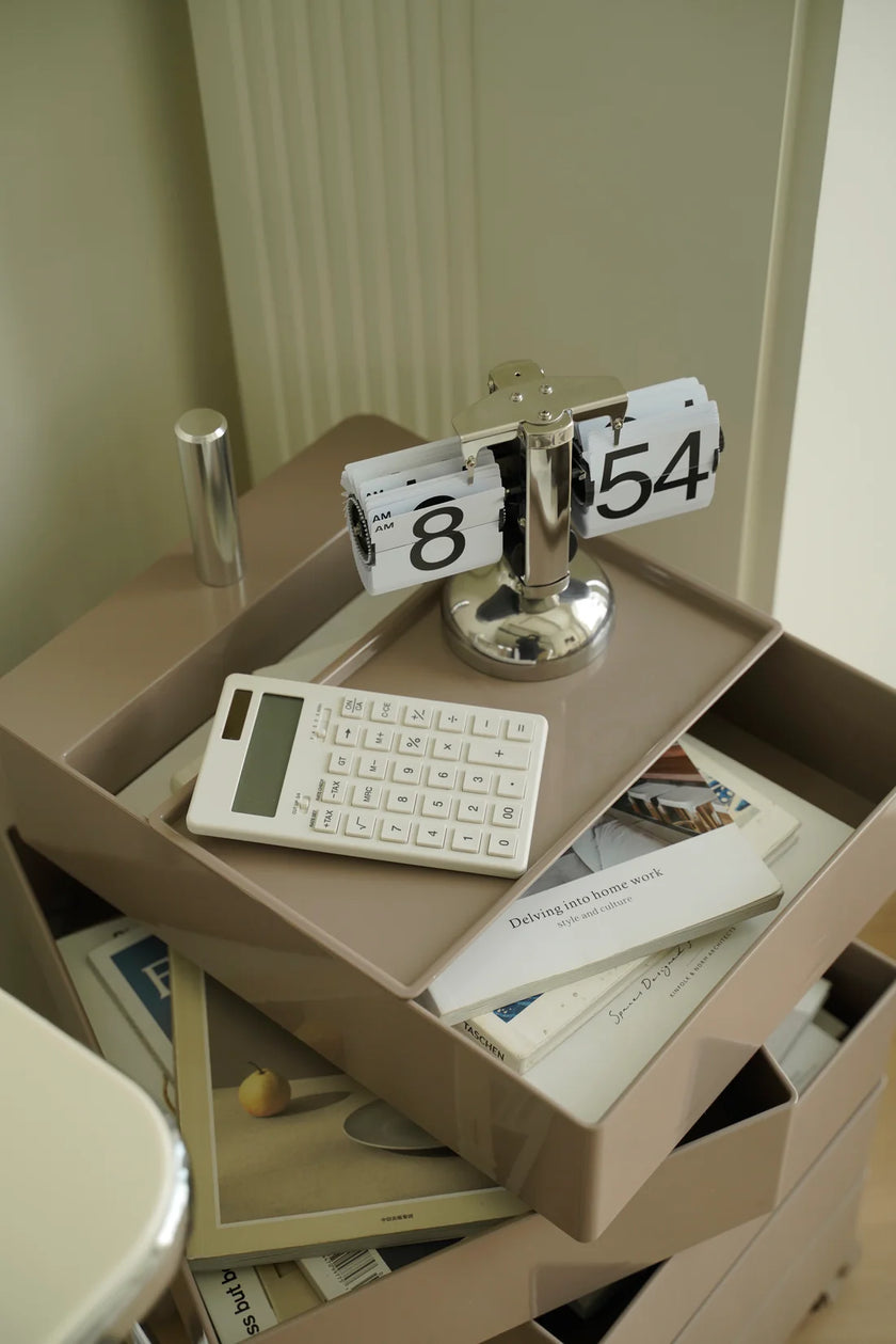 Open storage containers with 10 drawer rolling cart, have a keyboard, calendar, and other items on a white surface.