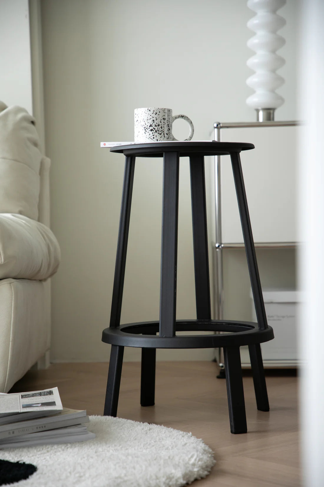 Black counter height bar stools with a mug and books in a living room setting