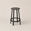 Black bar stool on a beige background