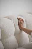 Hand touching a textured white Fabric on a sofa