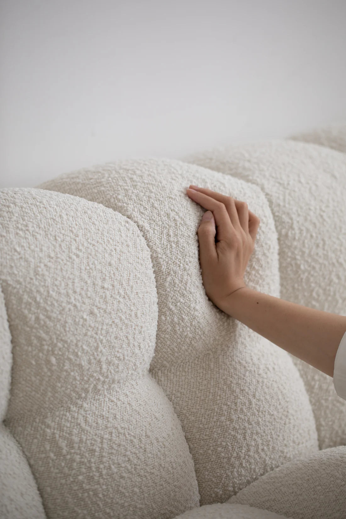 Hand touching a textured white Fabric on a sofa