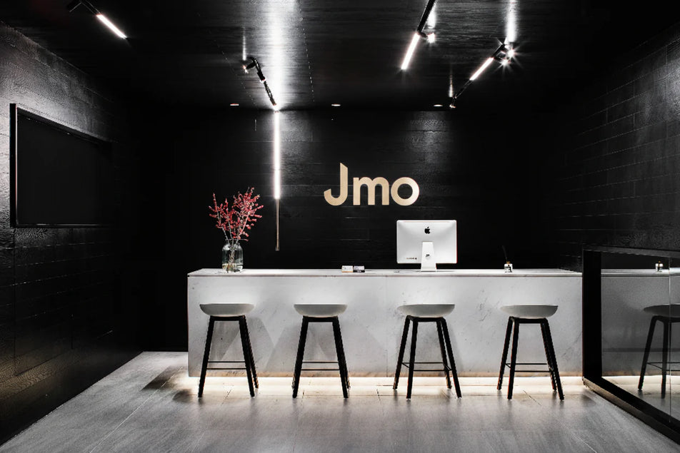 Modern interior with a reception desk and 'Jmo' logo on the wall.
