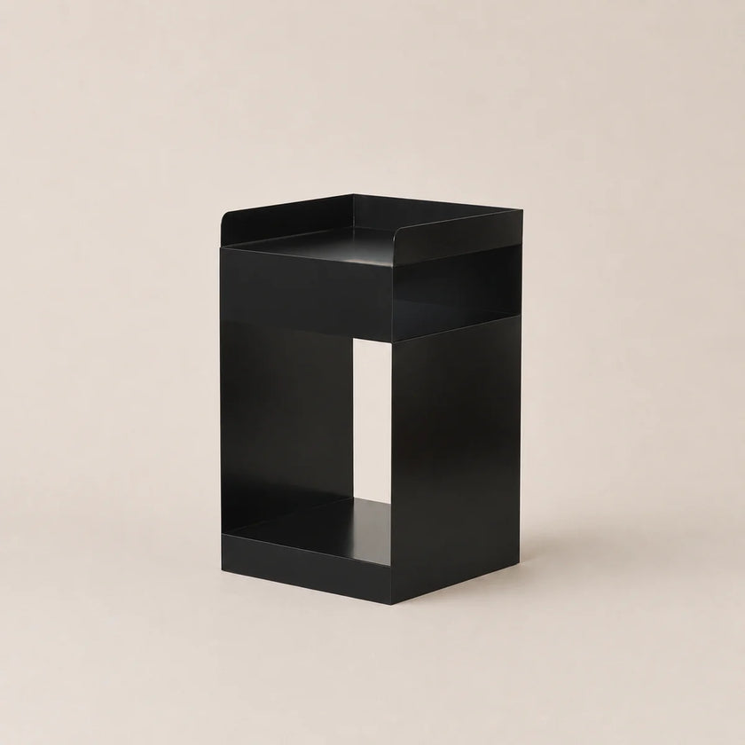 Black metal side table on a beige background