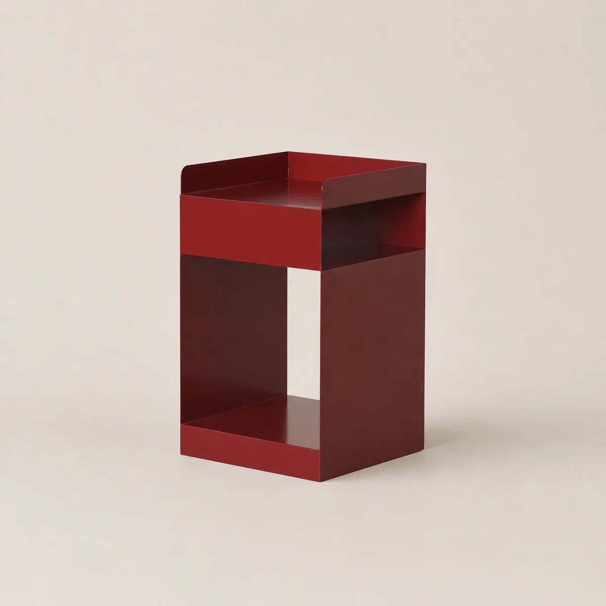 Red metal side table on a beige background