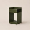 Green side table on a beige background