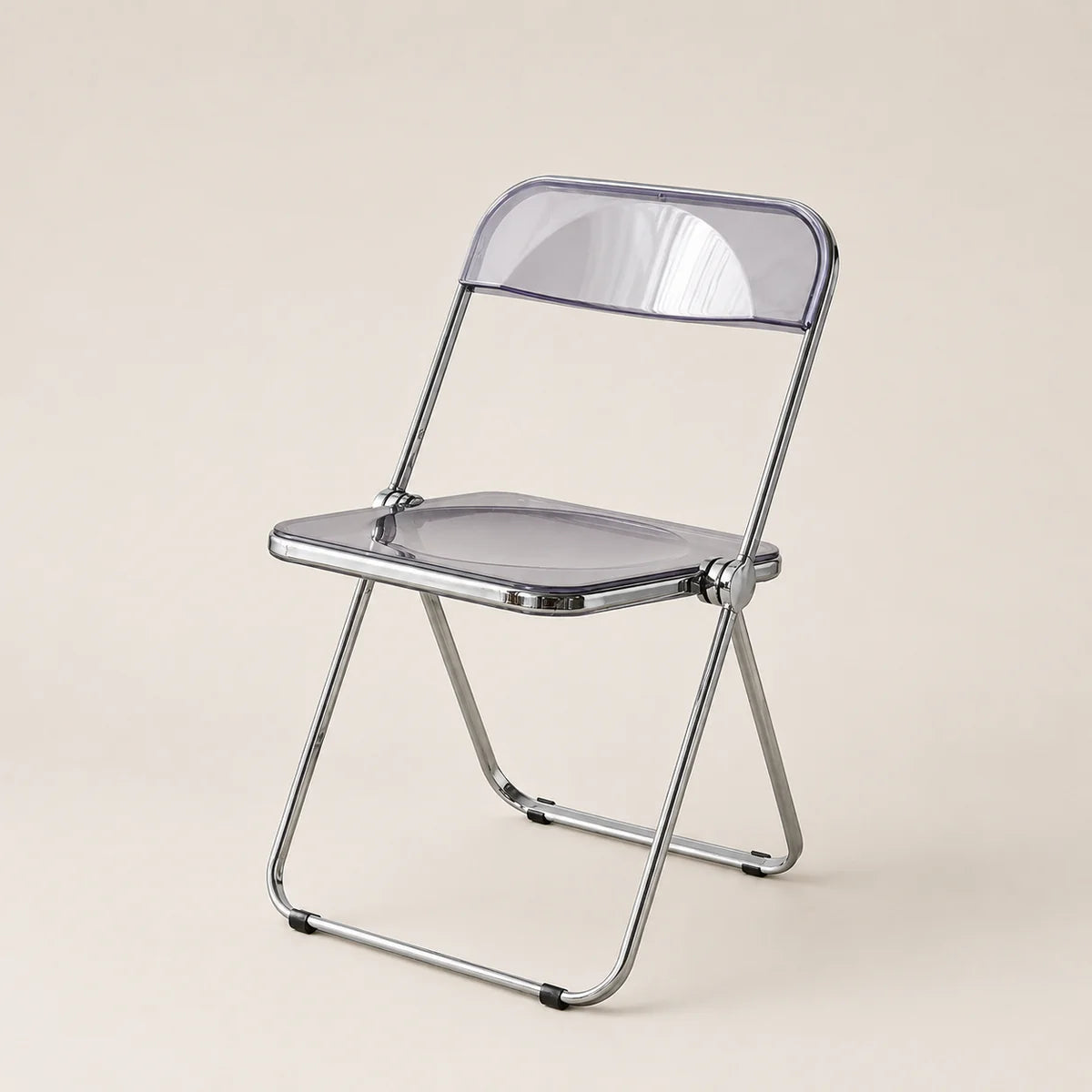 Clear plastic folding chair with metal frame on a beige background
