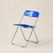 Blue folding chair with transparent backrest on a beige background
