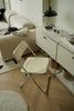 Modern living room with a white folding chair, sofa, and side table.
