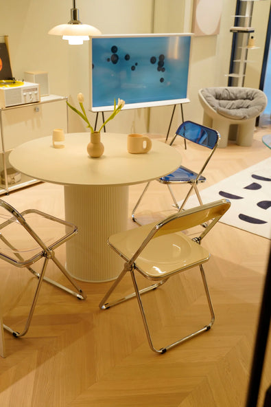 Round table with folding chairs in a room with a whiteboard on the wall.