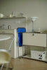 Modern office setup with a blue folding chair, white desk, and lamp.