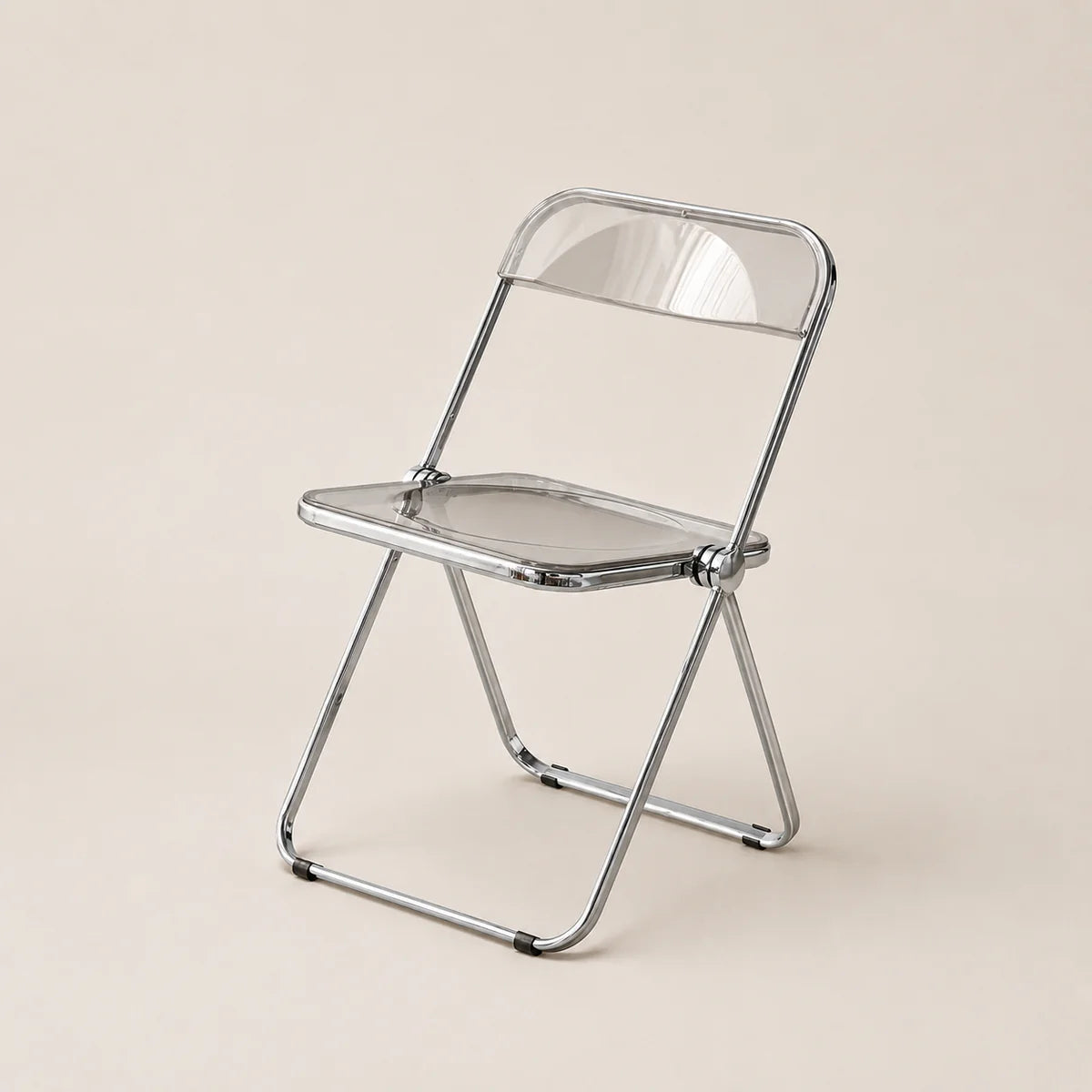 Clear plastic folding chair with metal frame on a beige background