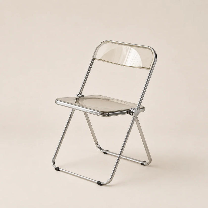 Clear plastic folding chair with metal frame on a beige background