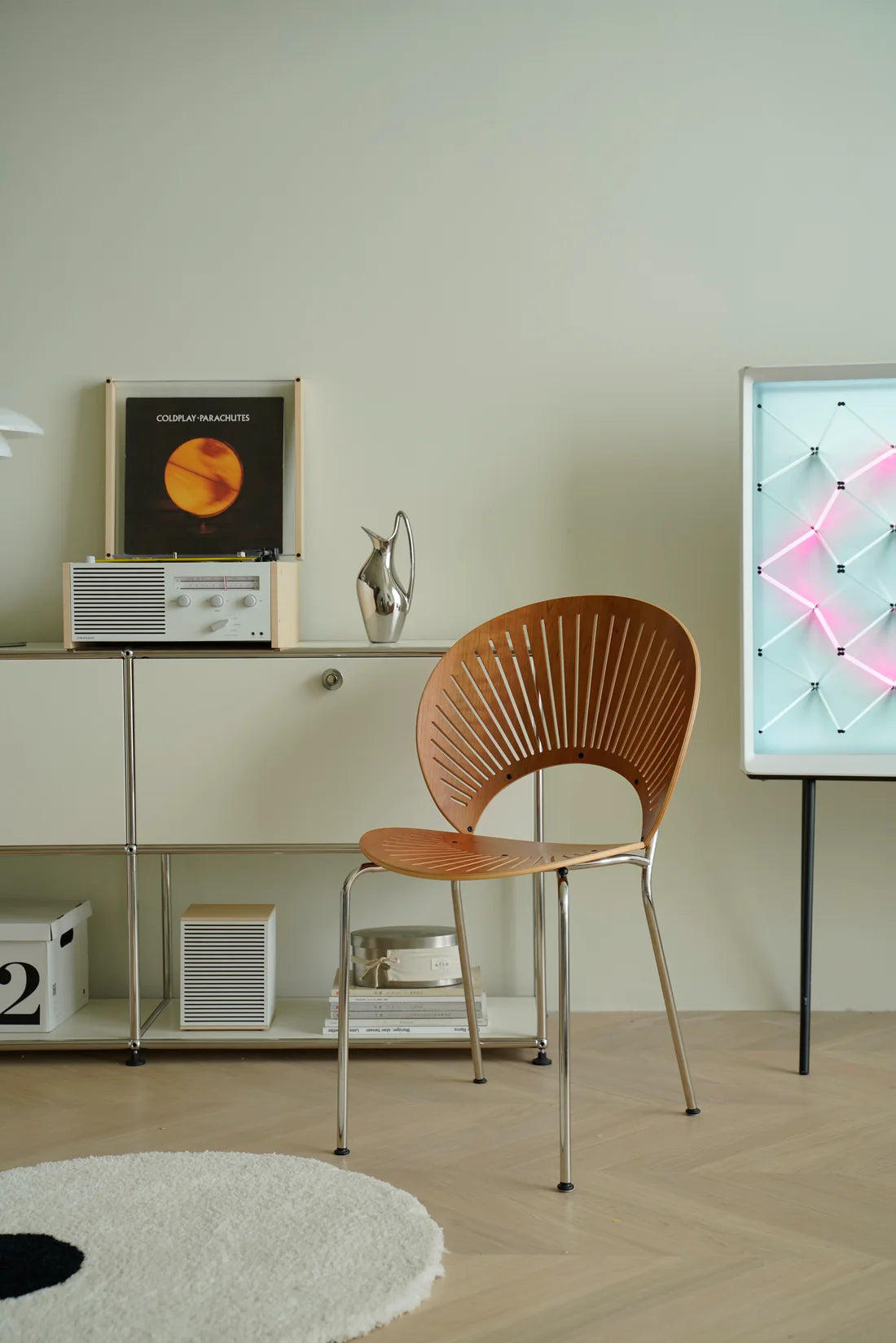 Modern interior with a wooden metal chair, shelf, and decorative items.