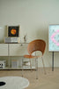 Modern interior with a wooden metal chair, shelf, and decorative items.