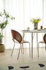 Modern dining area with a table and wooden chairs in a bright room.