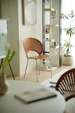 Modern interior with wooden living room chair, bookshelf, and decorative elements.
