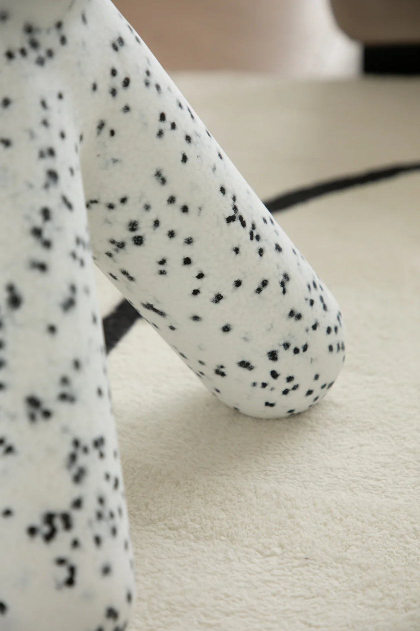 Close-up of a white cushion with black spots on a beige surface plastic kids chair