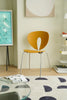 Modern room with a yellow dining room wooden chair, glass table, and abstract art on the wall.