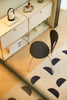 Modern interior with a sideboard, black wooden chair, and patterned rug.