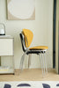 Yellow & white and black dining room chair stacked on a wooden floor with a neutral wall background