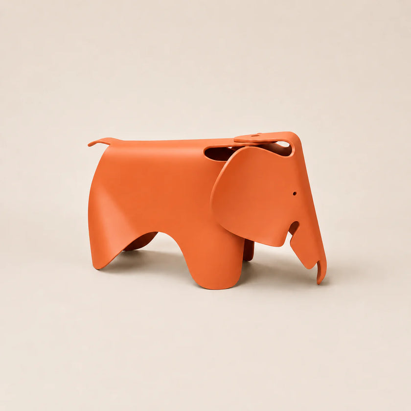 An orange elephant-shaped pp container with a matte finish, photographed on a clean, solid light beige background.