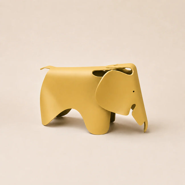 A ginger yellow elephant-shaped stool with a matte finish, shown from a side profile against a solid beige background.