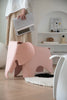 Pink elephant-shaped kids plastic stool in a modern room with a person holding a book.