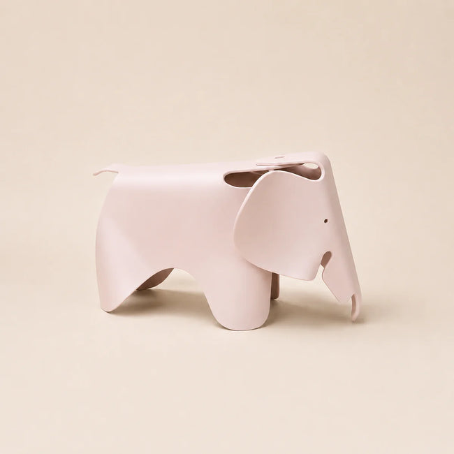 A light pink elephant-shaped stool with a matte finish, shown from a side profile against a solid beige background.