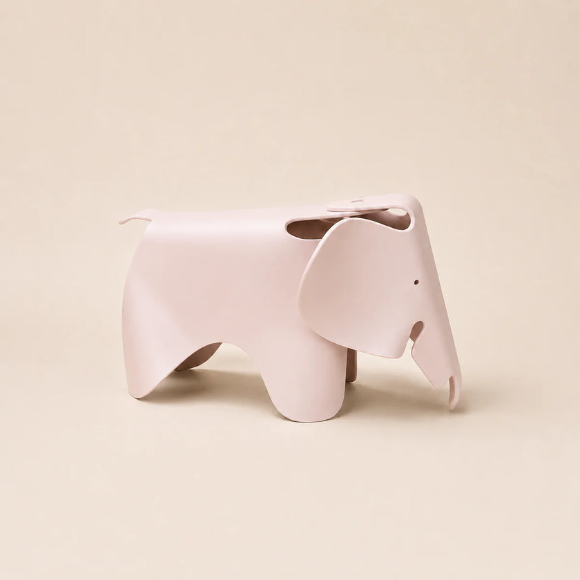 A light pink elephant-shaped stool with a matte finish, shown from a side profile against a solid beige background.