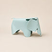 A light blue elephant-shaped stool with a matte finish, shown from a side profile against a solid beige background.