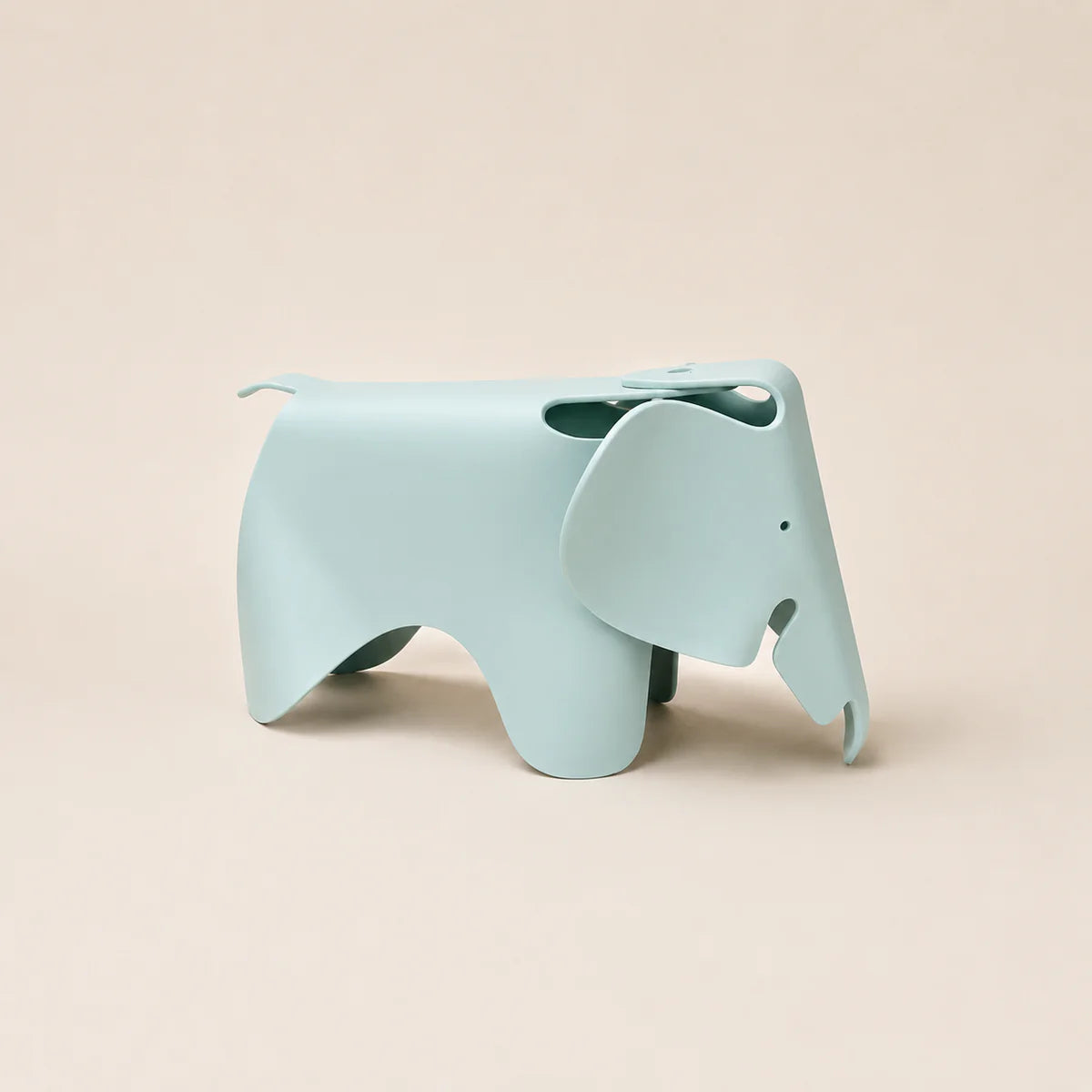 A light blue elephant-shaped stool with a matte finish, shown from a side profile against a solid beige background.